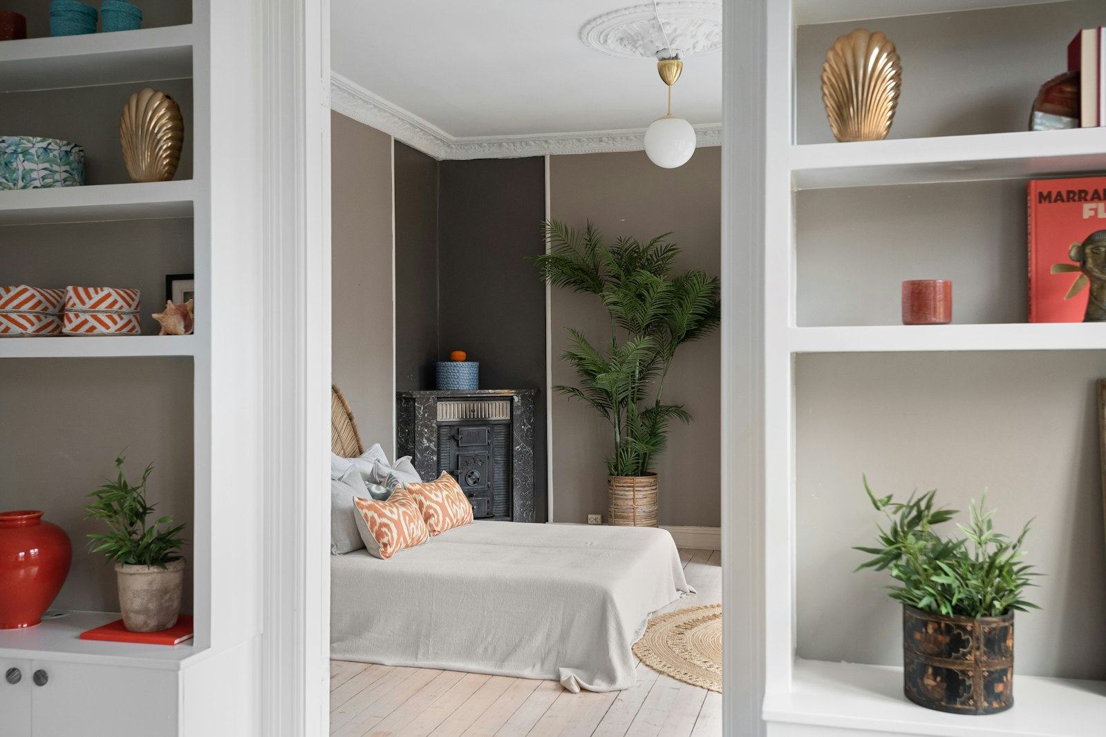 A bright bedroom with shelves full of plants