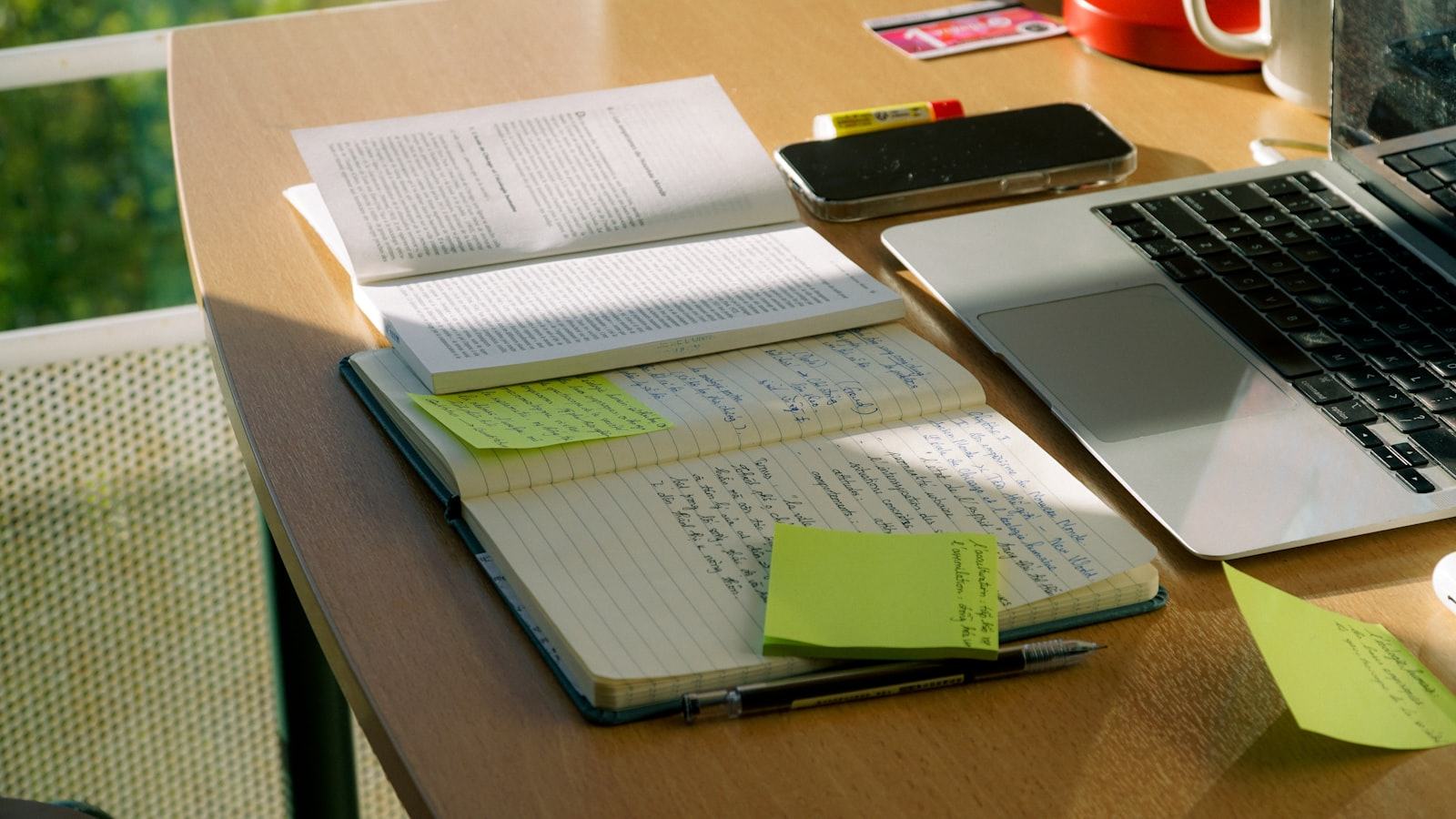 A workspace desk with a notebook and laptop