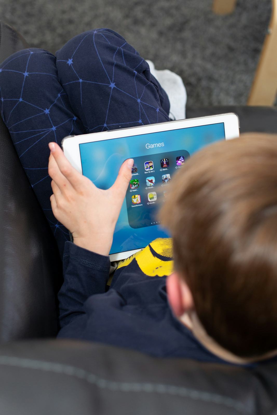 A young boy on a couch using a tablet