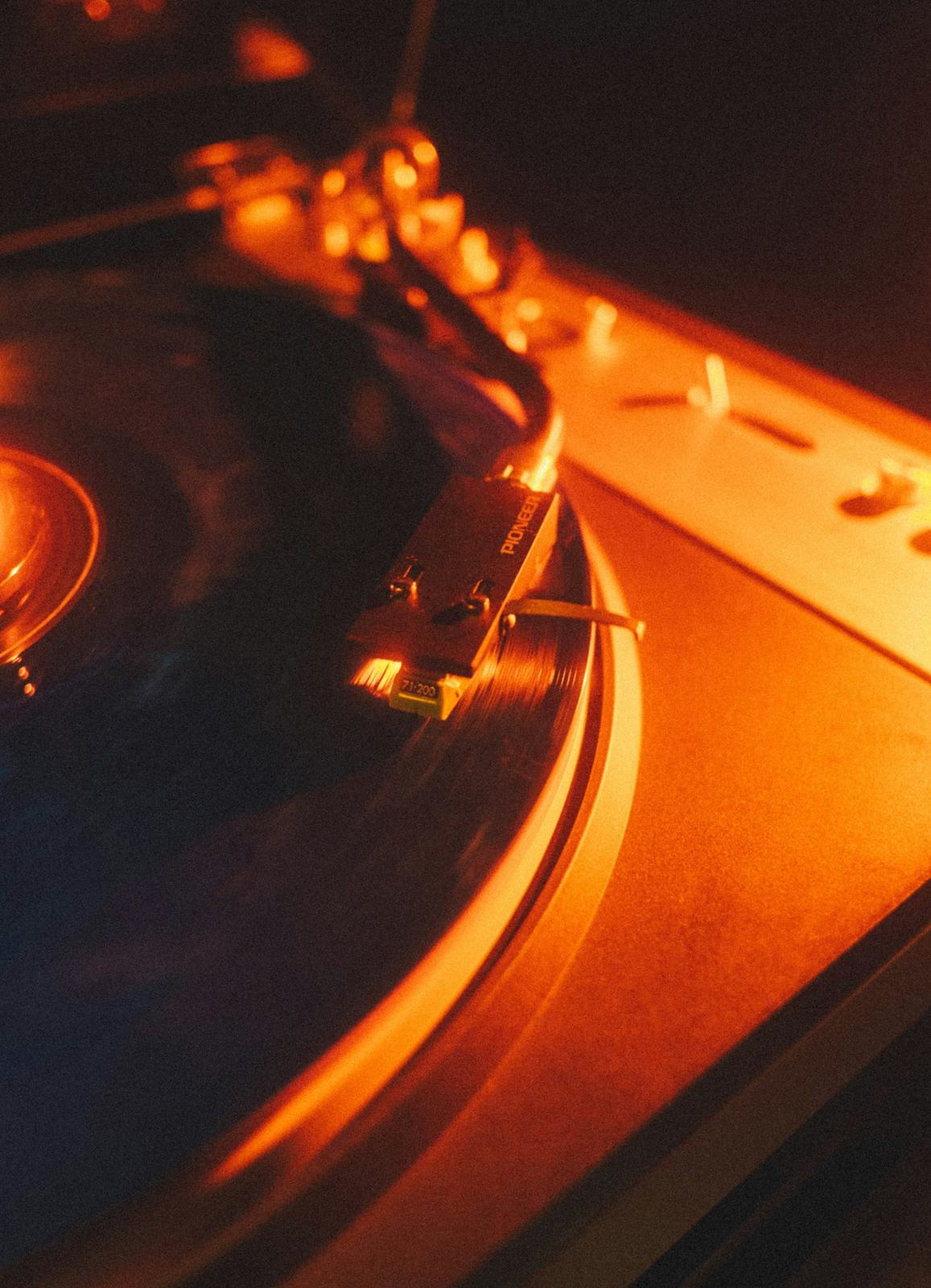 A turntable playing a vinyl record in warm evening light