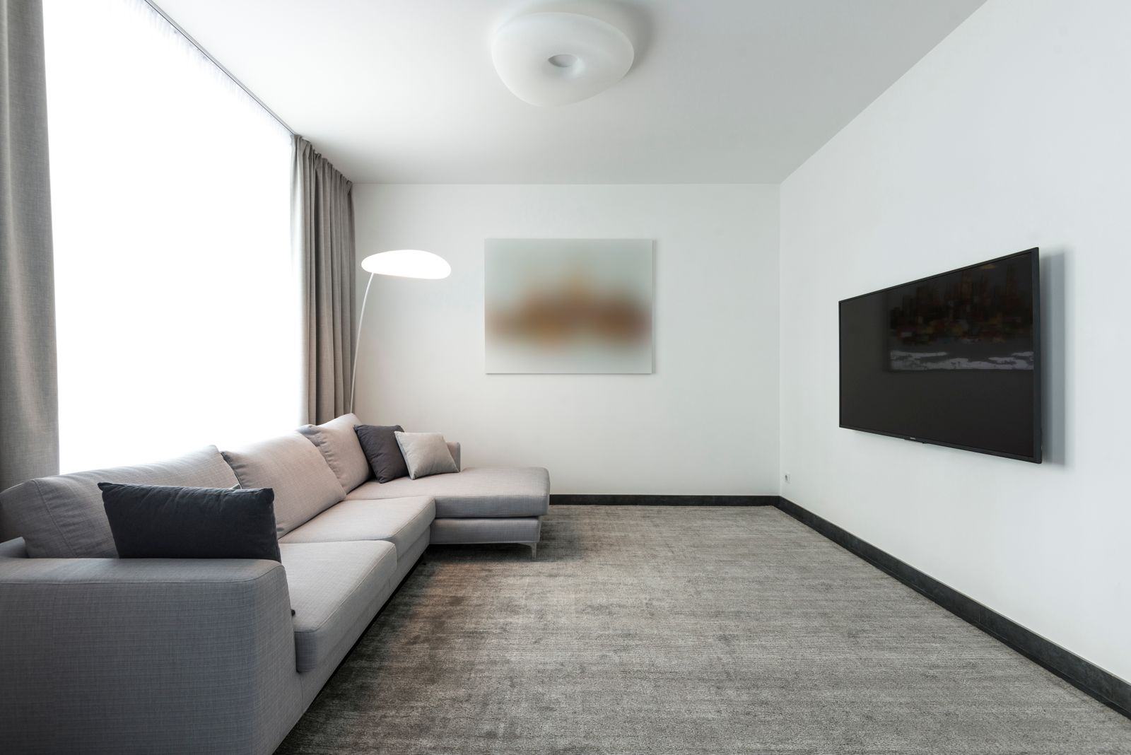 A contemporary living room with clean carpeted floor