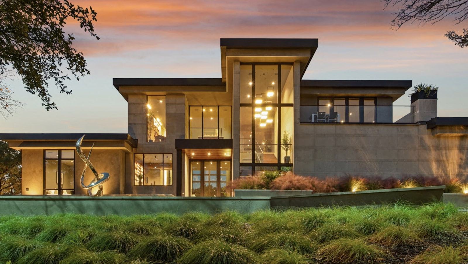 A modern house exterior with glowing windows at dusk