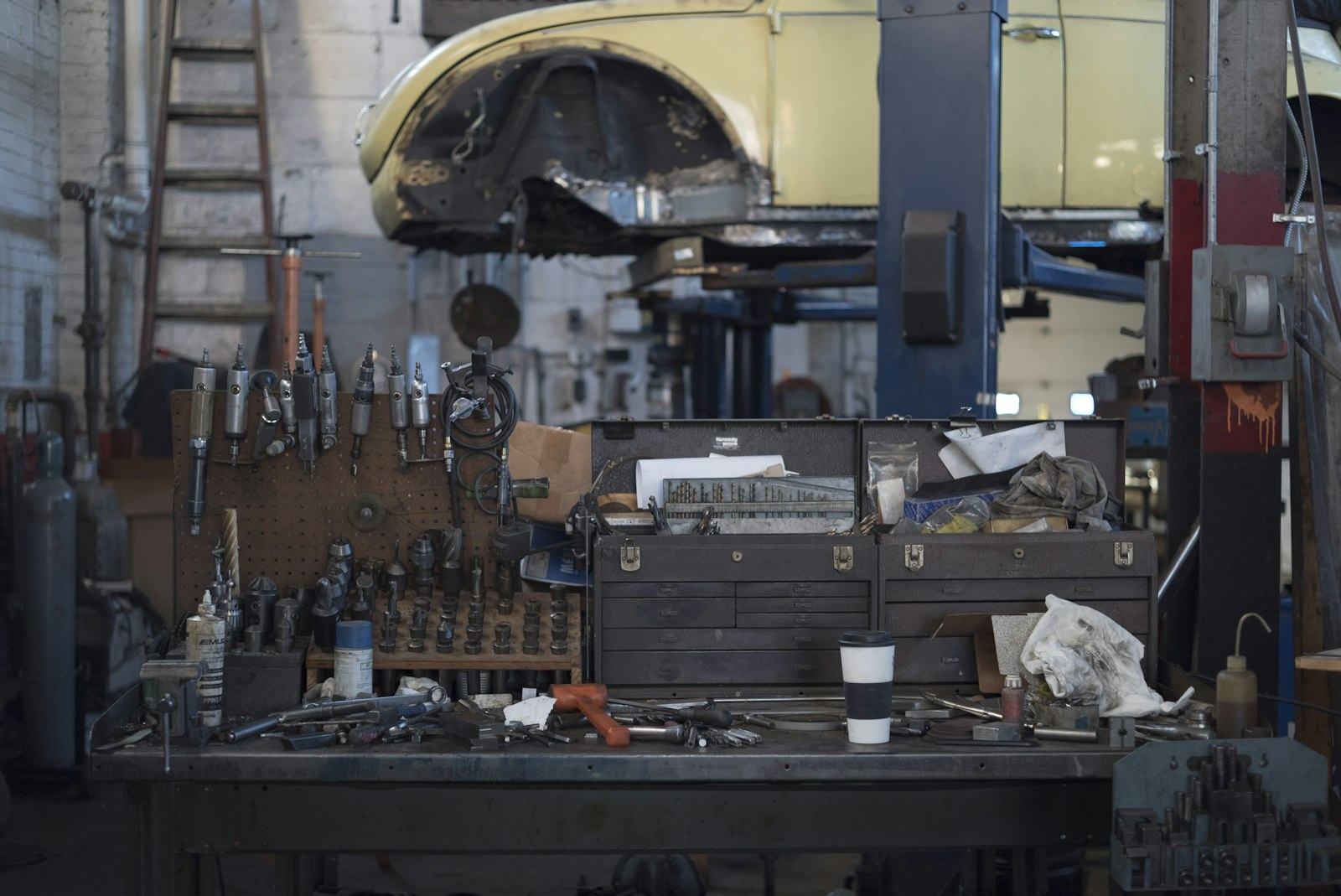 A workbench covered in tools, lit from one side